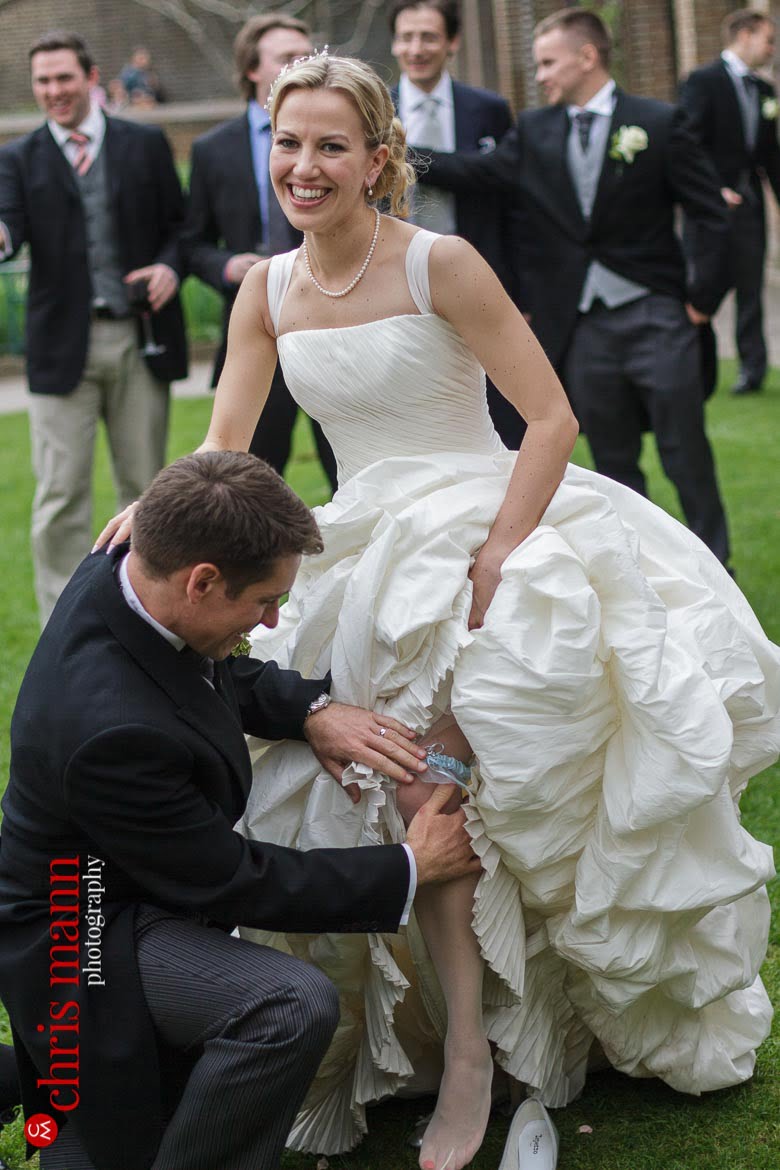 Orangery Holland Park Wedding groom removes bride's garter