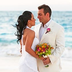 Destination wedding planning tips - couple embracing on beach