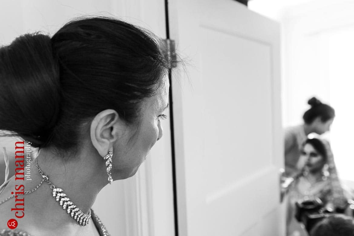 mother of bride watches as her daughter gets ready