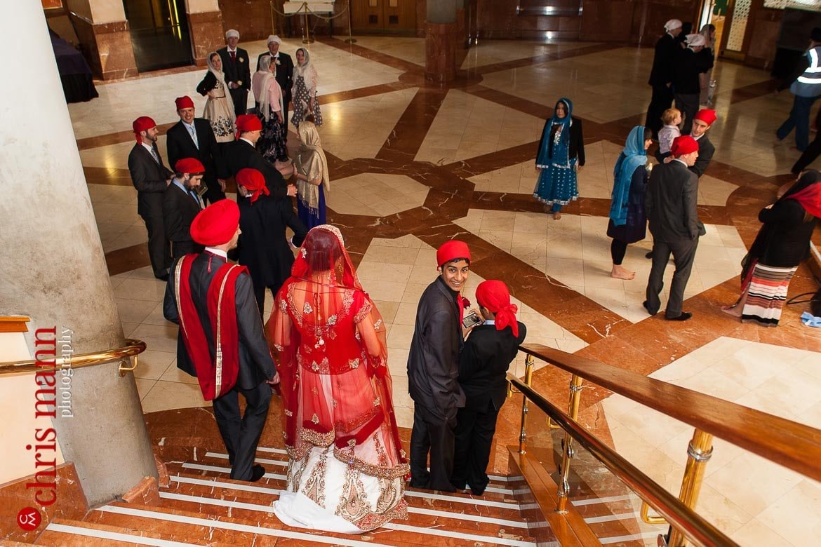 bride and groom descend stairs after Sikh wedding ceremony at Sri Guru Singh Sabha gurdwara Southall