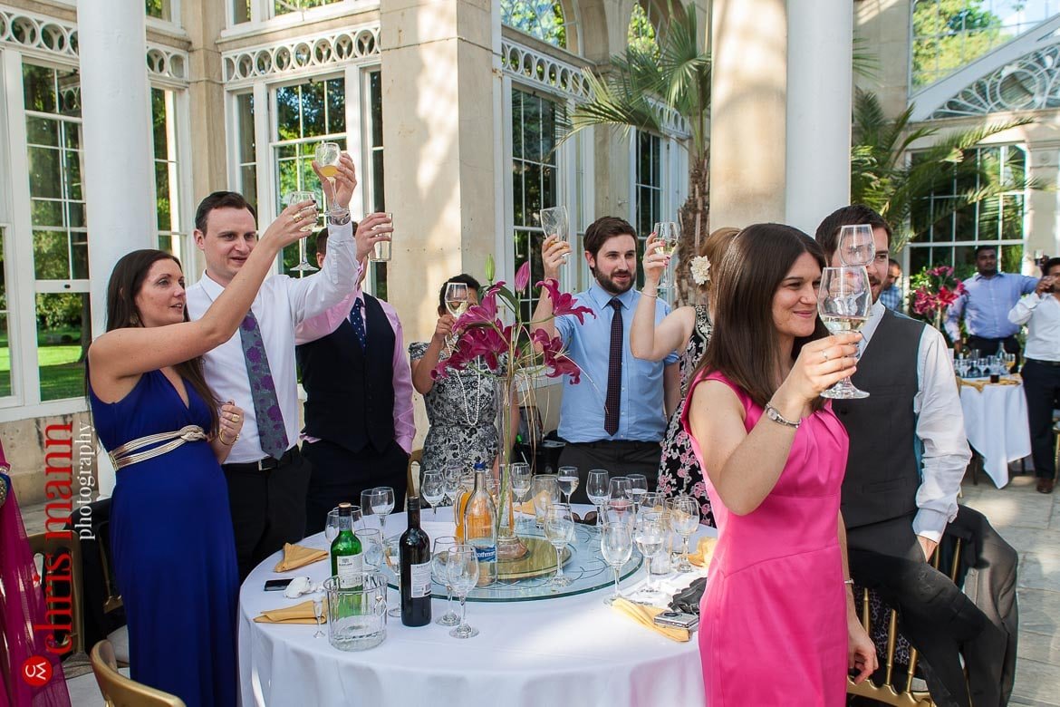 guests toast bride and groom at reception Syon Park Great Conservatory