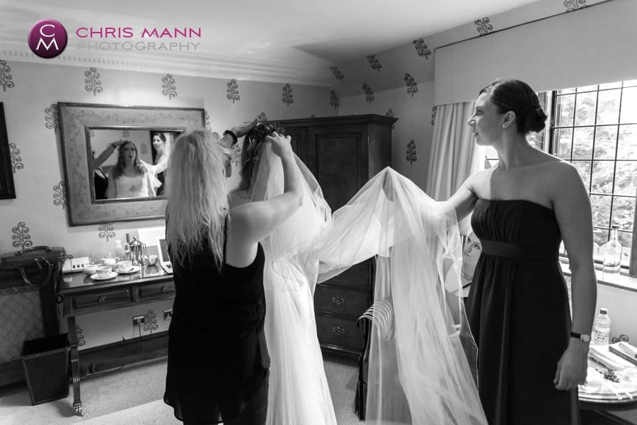 bride in room getting ready dons veil