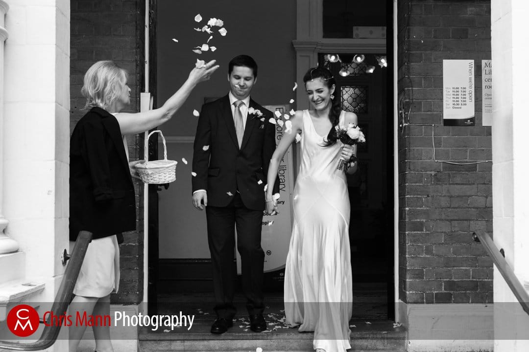 bride and groom exit Mayfair Library wedding to a shower of confetti