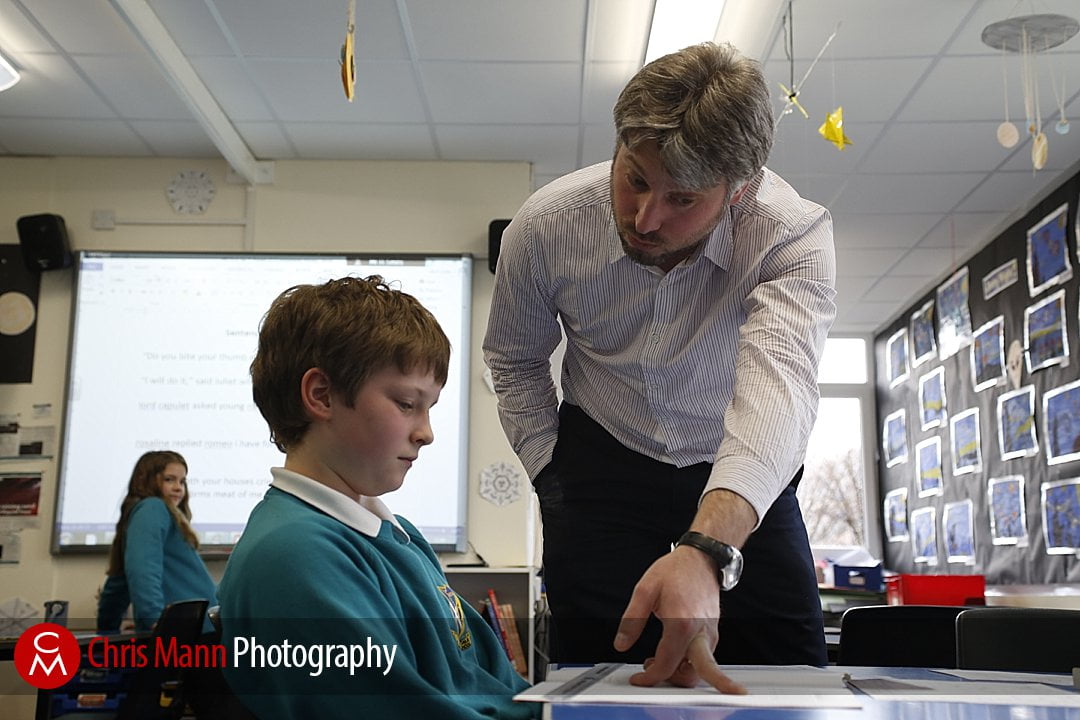 teacher helps child with their work