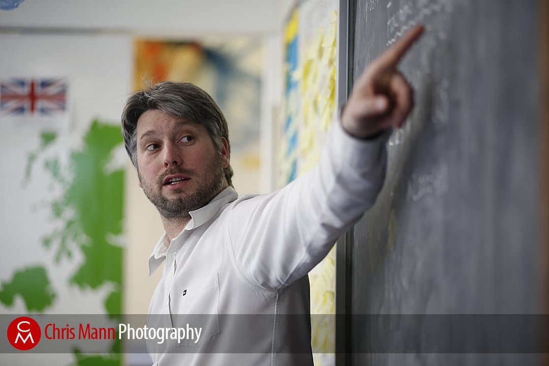 teacher points at blackboard