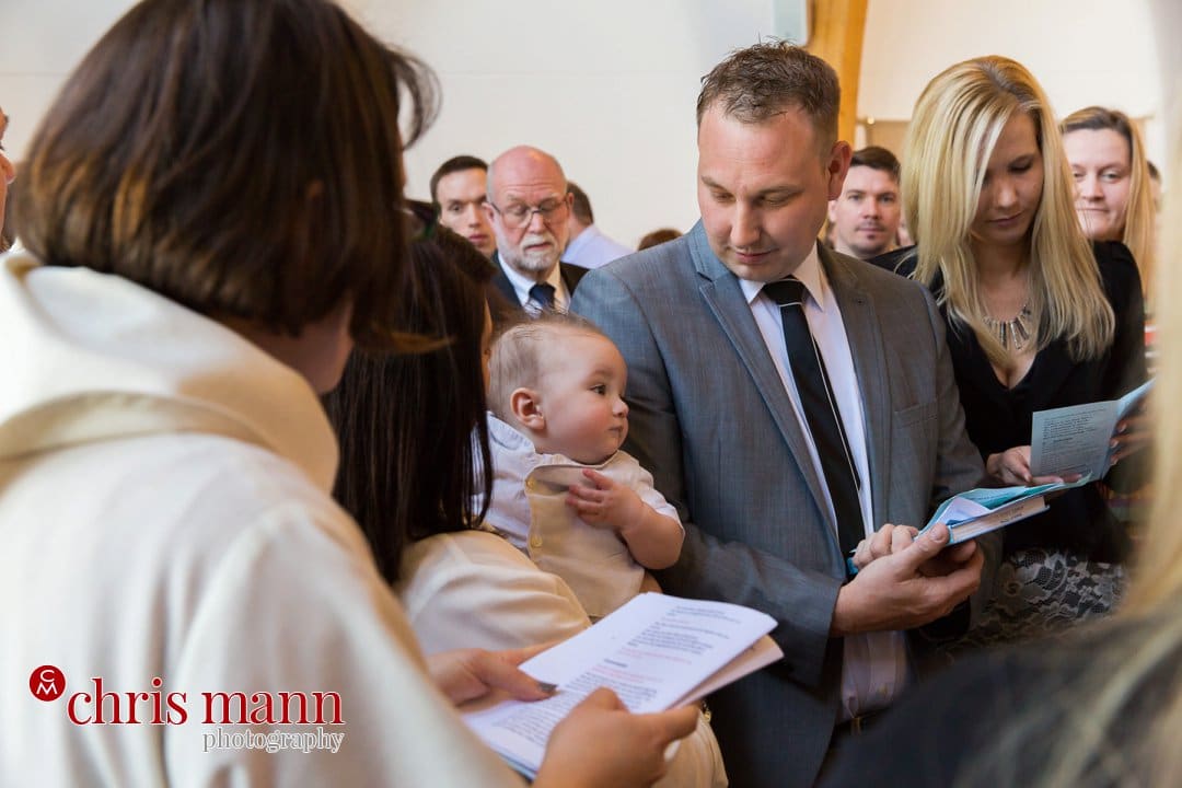baby with parents christening ceremony