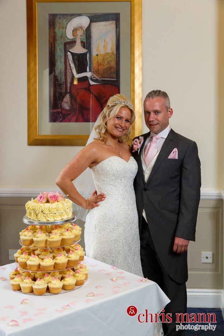 bride and groom pose with wedding cake