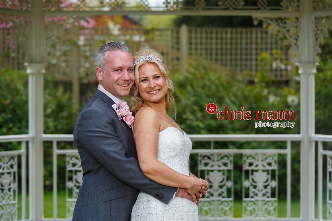 bride and groom in gazebo Manor House Hotel Guildford