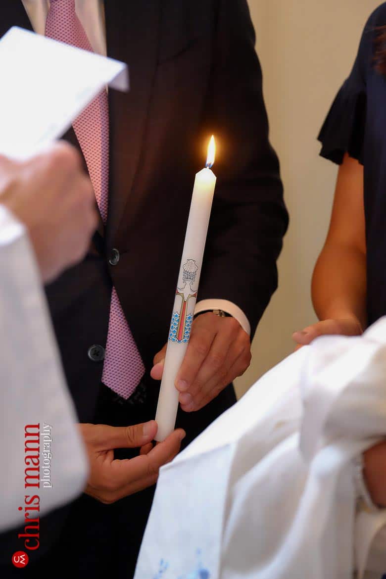 godfather holding candle at christening ceremony Brompton Oratory Knightsbridge London 