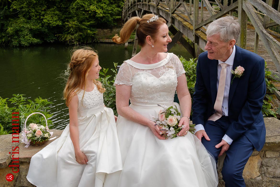 bride and groom with flower girl on terrace of Trout Inn Wolvercote Oxford