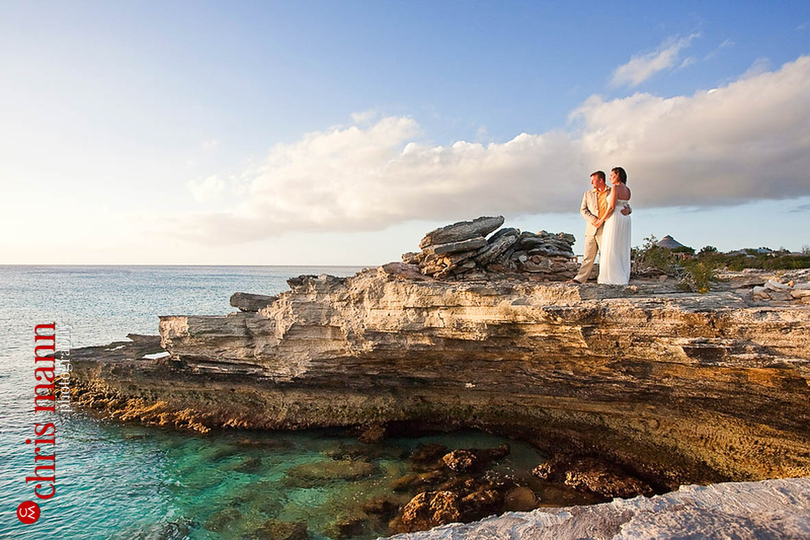 Turks & Caicos honeymoon shoot couple posing on rocks by ocean Amanyara resort Providenciales
