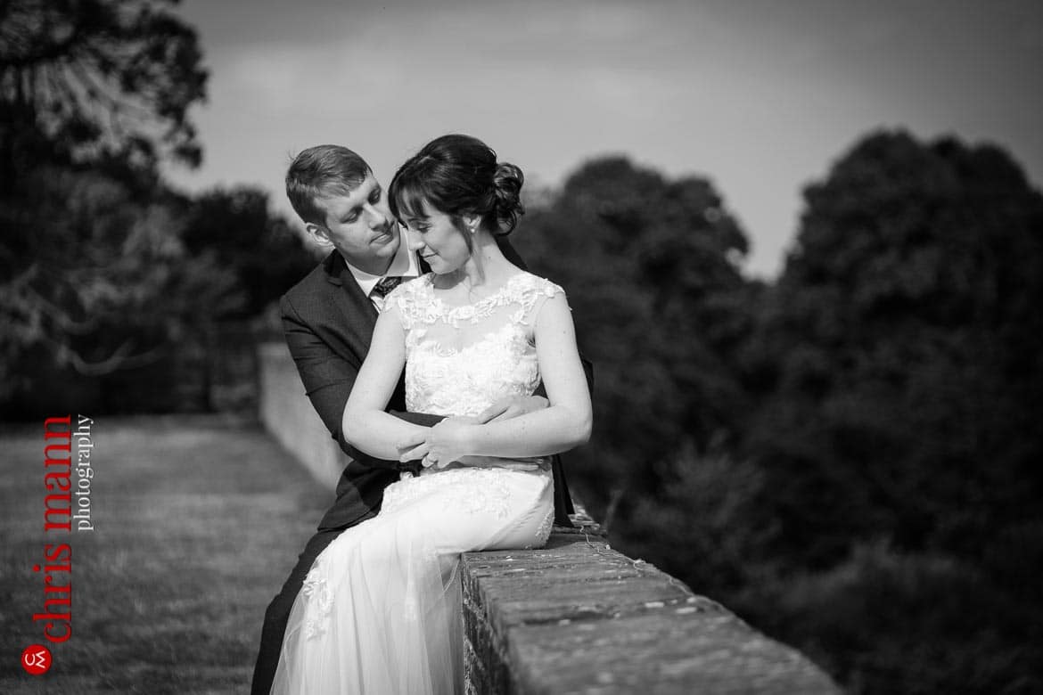bride and gromo sit on wall Farnham Castle anniversary shoot