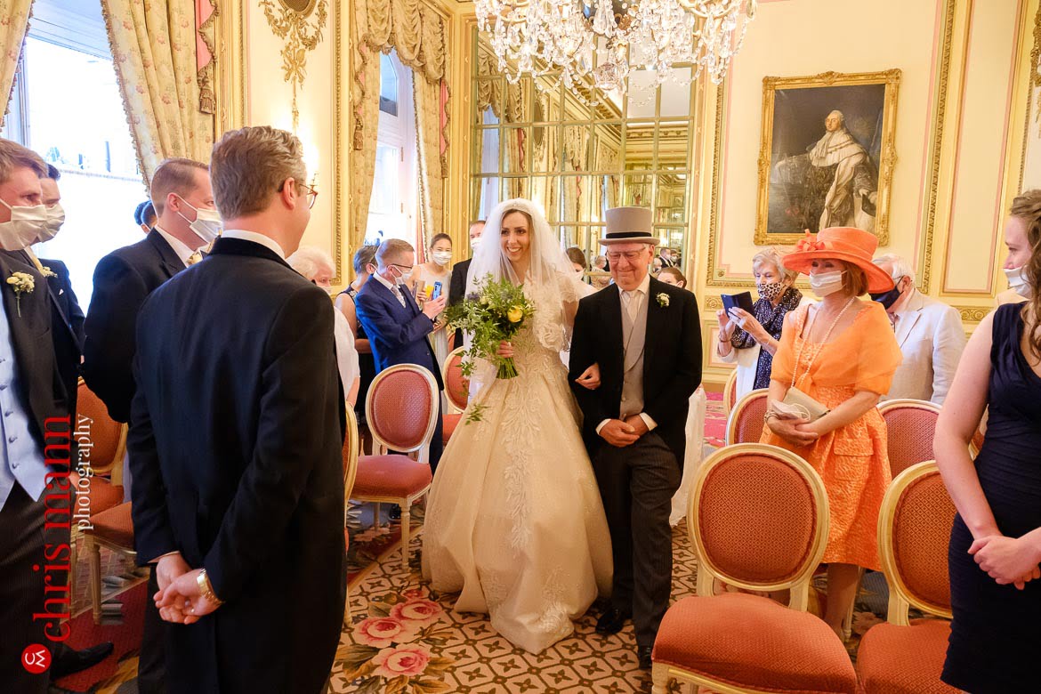 father escorts bride down the aisle as groom looks on - Ritz London wedding photography