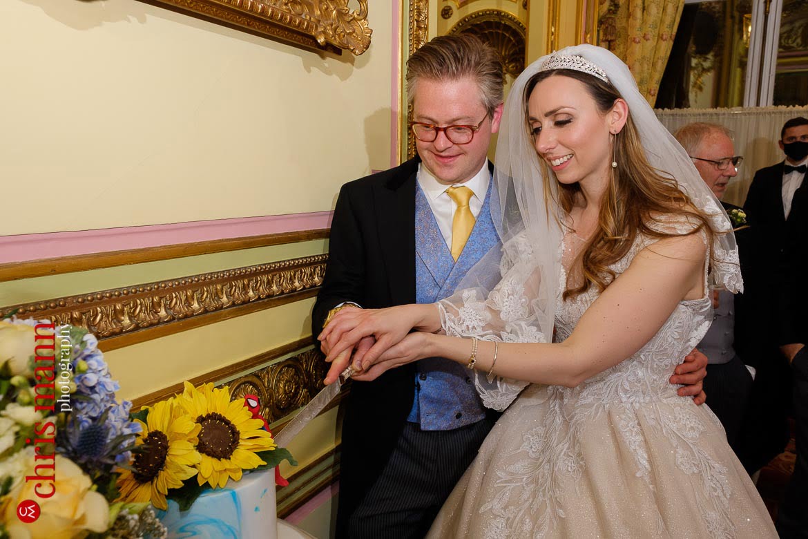 bride and grom cut the wedding cake in the Marie Antoinette Suite - wedding photographer london ritz piccadilly